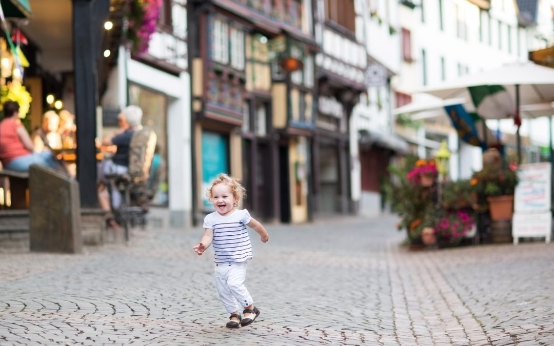 happy toddler runs down street lined with shops have they escaped